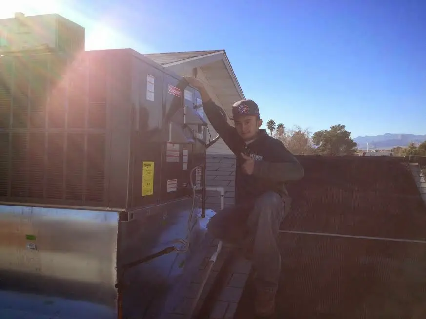 HVAC technician performing Heat Pump Repair on a rooftop unit in East End